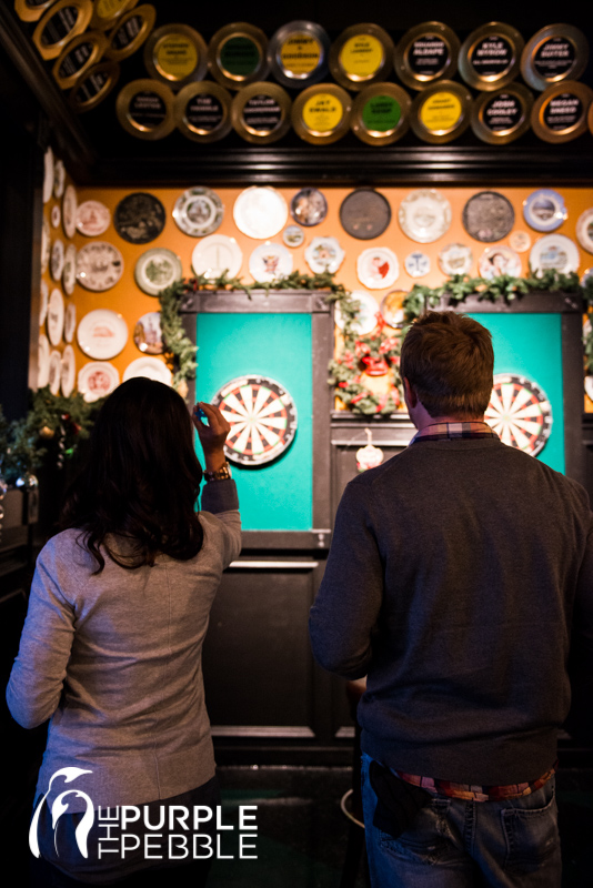 couple playing darts engagement photography