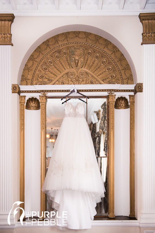 elegant bridal ballgown hanging in mirrored ballroom ywca